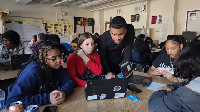 Students working together on laptops in a classroom